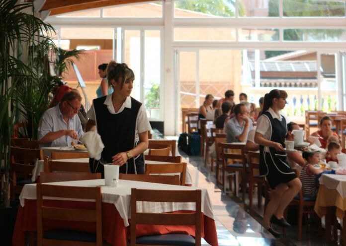 702_restaurant_in_einem_hotel_in_cala_millor_-_kellnerinen_bei_der_arbeit.jpg  Foto: Servitører på et hotell ved feriestedet Cala Millor på Mallorca (Wikimedia Commons 2012).