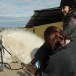 Bethany-får-hjelp-til-å-justere-seletøyet-før-ridetimen