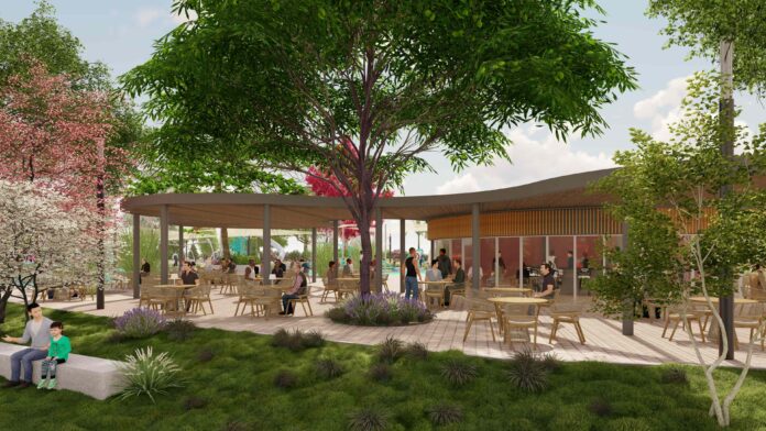 Outdoor cafe or plaza with trees, shaded seating under a curved pavilion and people dining outdoors by a building.